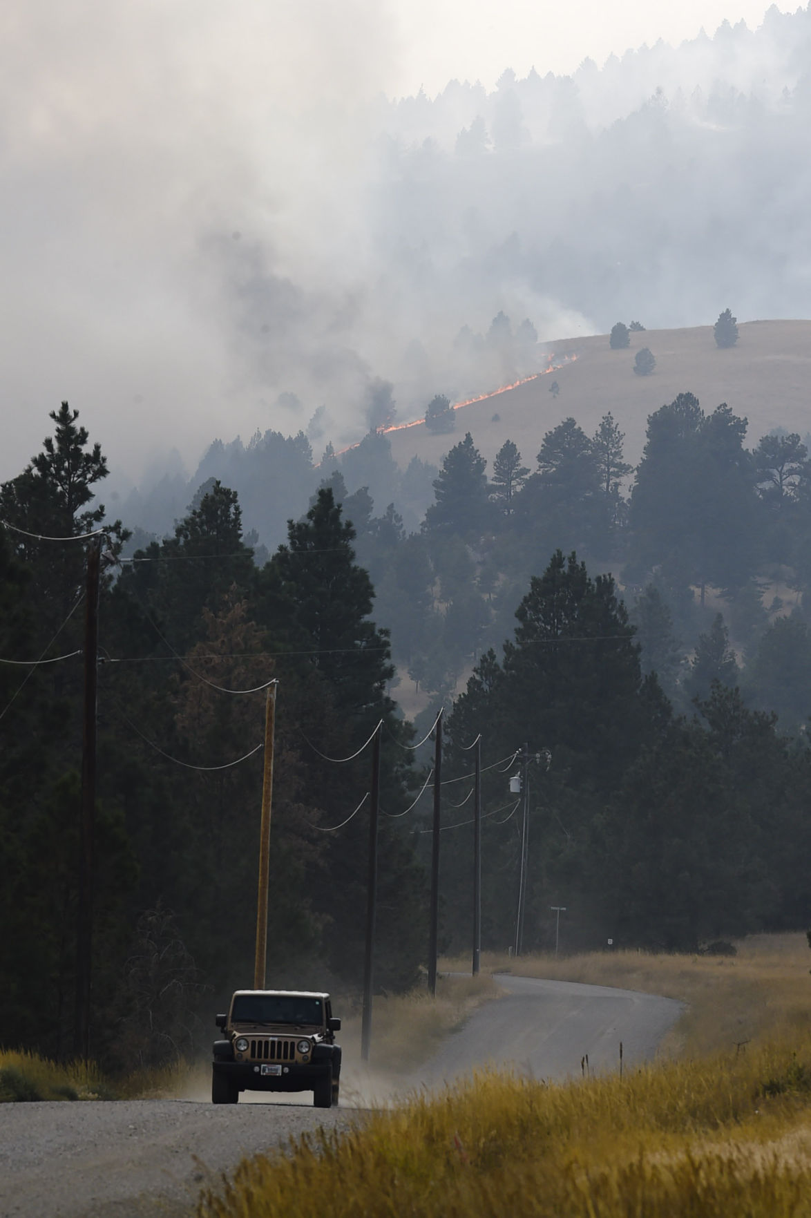A resident flees the area of a lightening caused fire south of Helena Thursday.